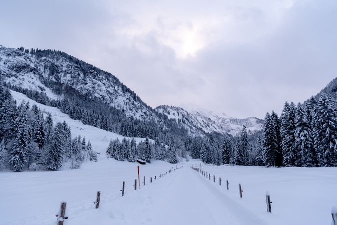 Snow-covered road passing through an alpine valley in the Bavarian Alps, Germany
