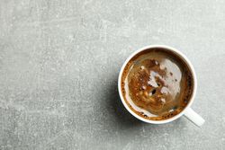 Cup of coffee on grey background, space for text