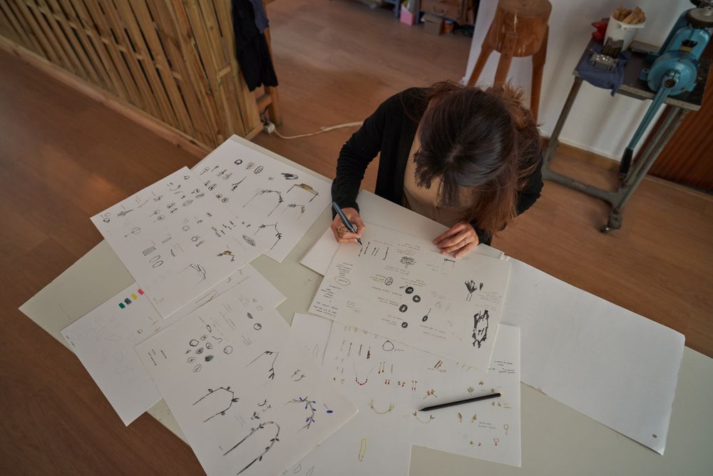Female designer painting sketches on paper