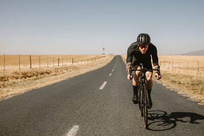 Athlete taking a bicycle ride on empty road