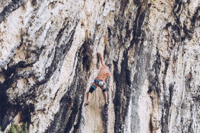 Anonymous man climbing rock