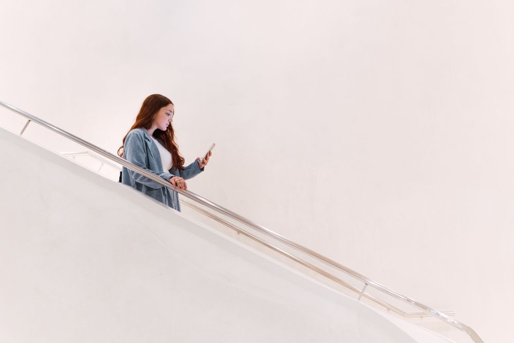 Woman browsing smartphone on staircase