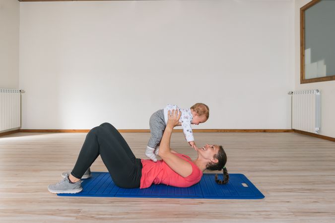 Mother exercising with baby in gym