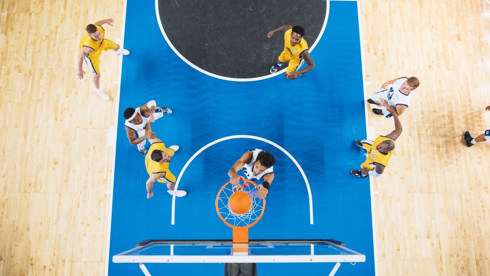 Basketball Tournament Final: Middle Of International Match With Basketballers Continuing Playing After Team Scored A Goal.