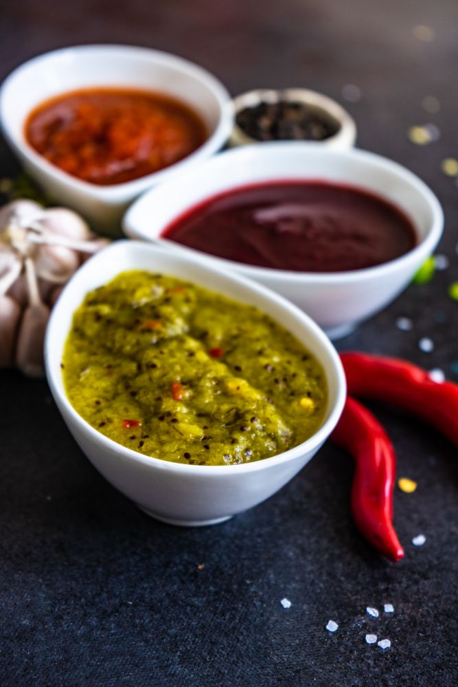 Close up of three flavorful spicy traditional Georgian sauces on dark counter
