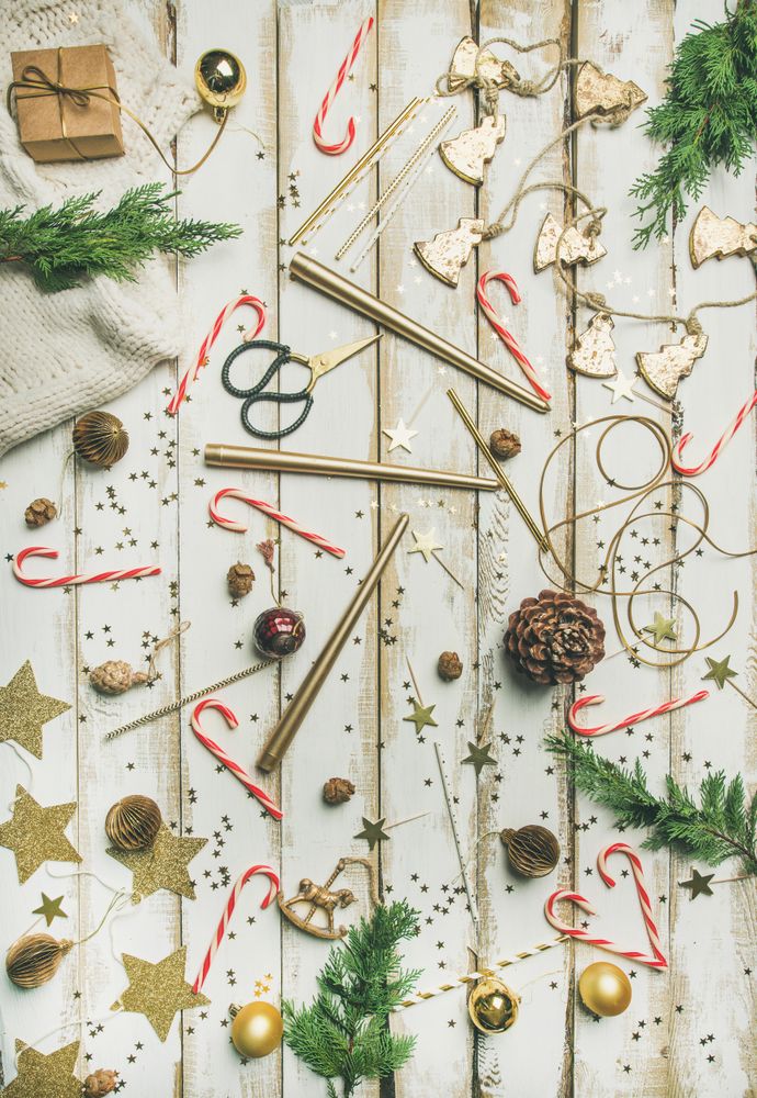 Decorations of stars, candy canes, scissors, candles on light background, vertical composition