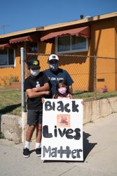 Los Angeles, CA, USA — June 7th, 2020: father and two children stand on sidewalk with protest sign