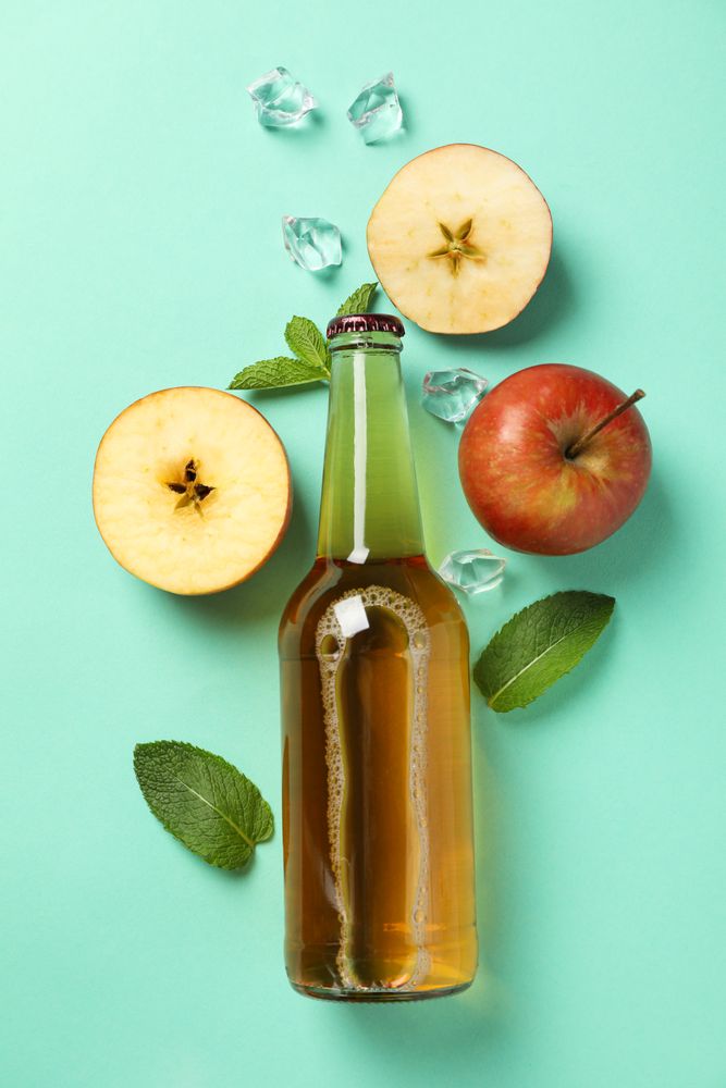 Composition with cider, apples and ice on mint background