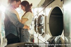 Cute young couple waiting for laundry in a laundromat 4AdPq5