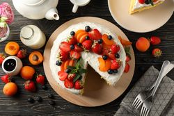 Composition with delicious berry cream cake on wooden table. Tasty dessert