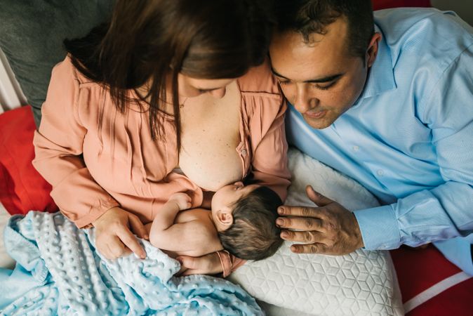 Mom near father breastfeeding at home