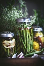 Fresh green vegetables with fruits and glass jars