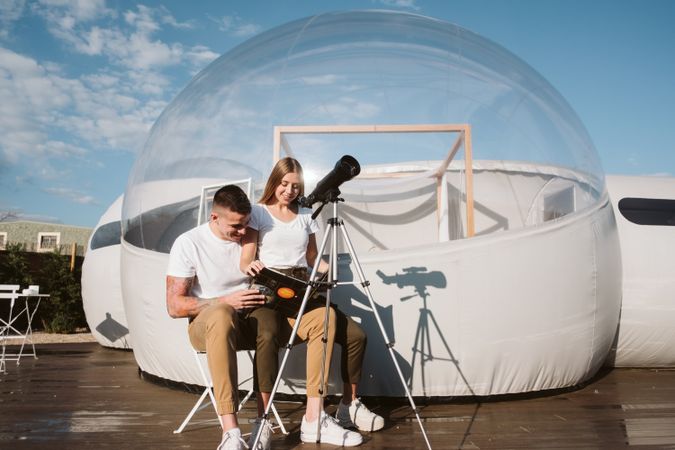 Young couple using astronomical telescope