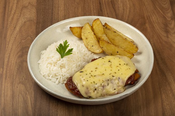 Parmigiana steak with rice and roasted potatoes. Typical Brazilian dish.