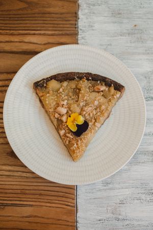 Brown pie decorated with flowers in woman hands