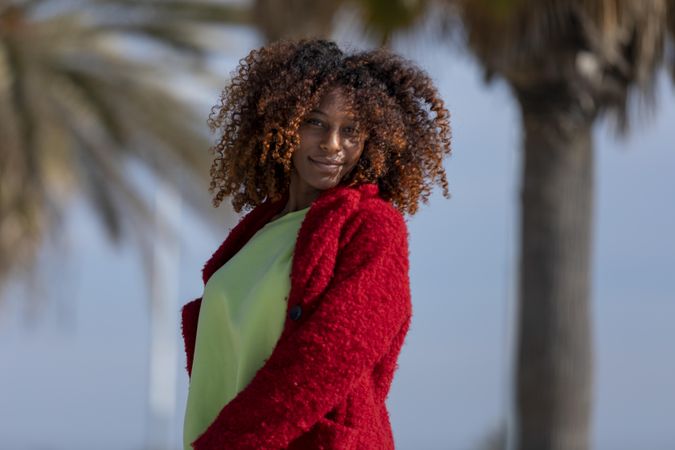 Calm female on sunny day standing on street with palm trees