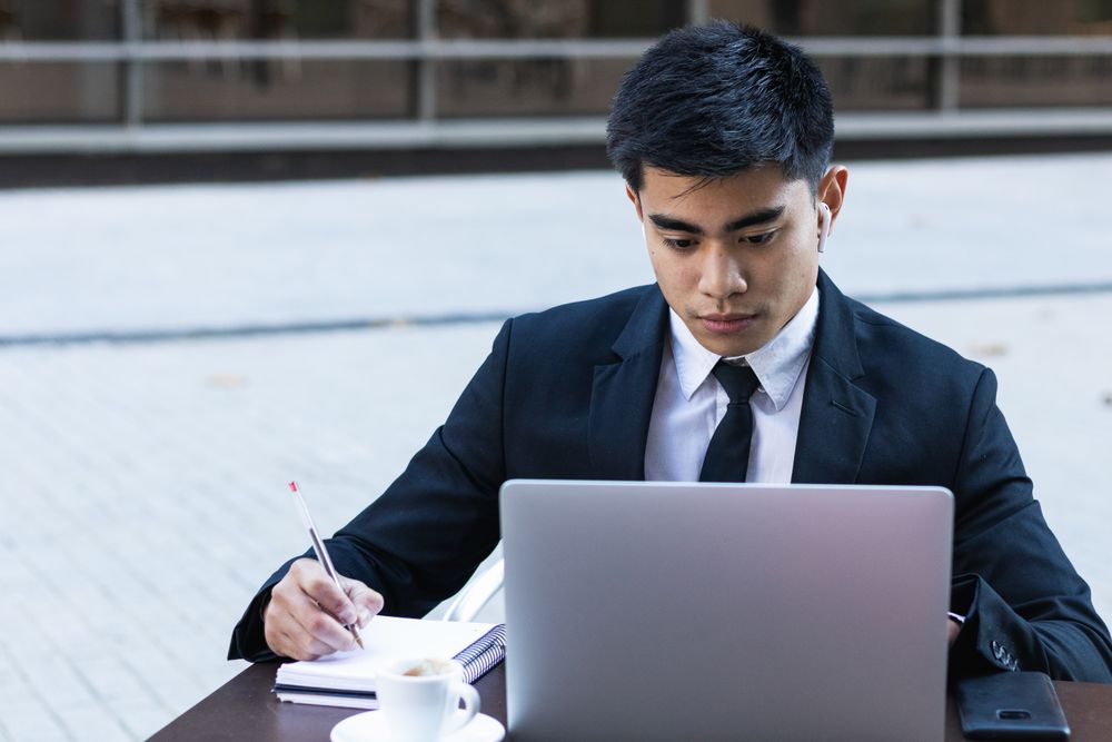 Serious male entrepreneur in suit working in cafe
