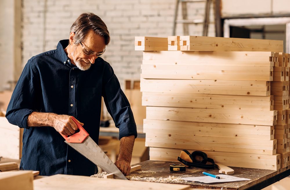 Man sawing wooden plank