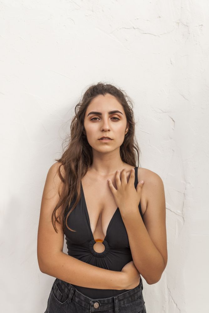 Female leaning on white wall