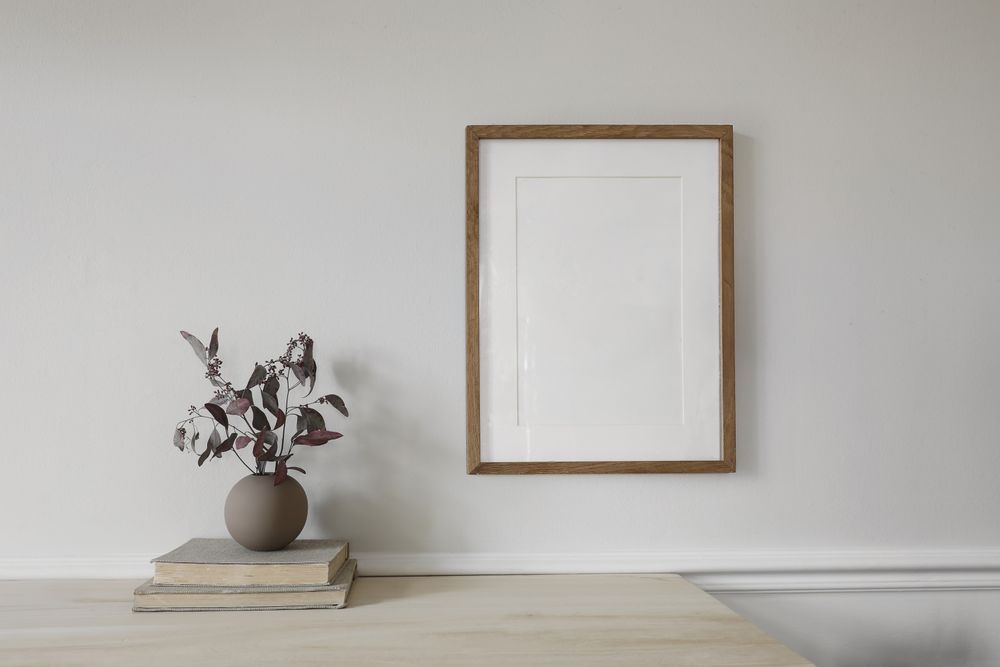 Blank vertical wooden picture frame mock up on wooden table.