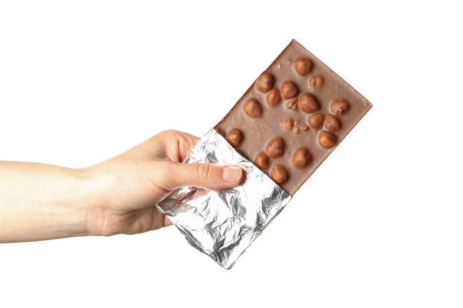 Female hand holding chocolate bar, isolated on blank background