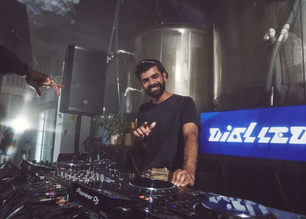 London, England, United Kingdom - Nov 9, 2022: Male DJ smiling as he mixes