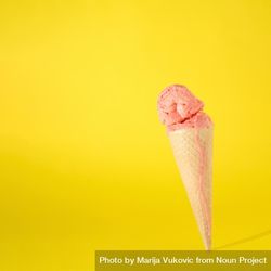 Cone with melting pink scoop of ice cream on yellow background 4jlo30
