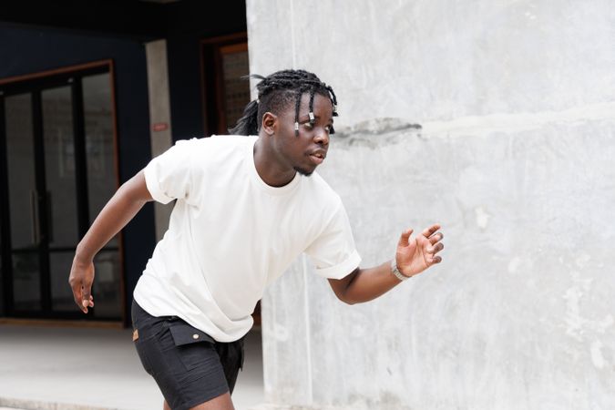 Black man in casual clothes standing running pose