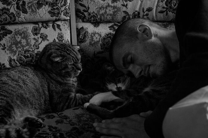 Man sleeping with a cat in a bed