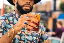 Black man having a drink in a bar terrace