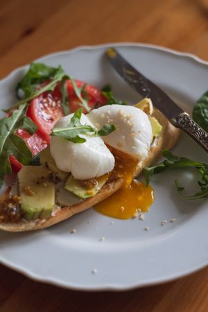 Toast with poached egg over avocado slices