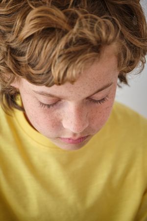 Crop lonely boy with closed eyes and brown hair