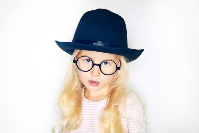 Serious blonde girl in hat and glasses