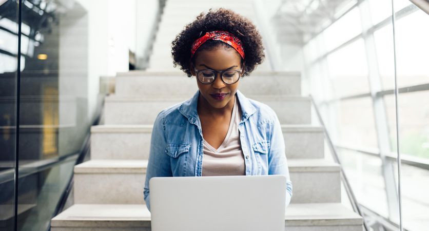 Woman sitting on a staircase with laptop