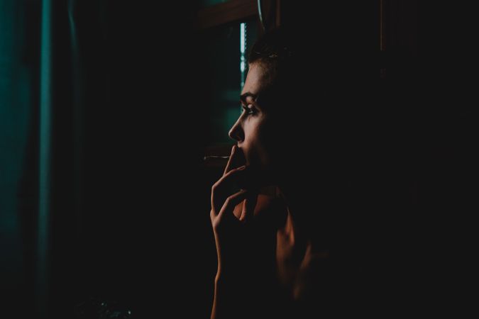 Woman smoking in a darkened room