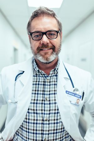 Portrait of happy and relaxed doctor standing in hospital