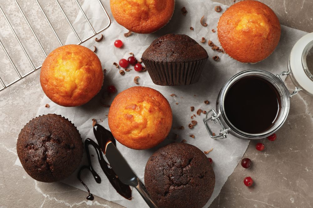 Composition with delicious muffins, berries, chocolate and baking paper