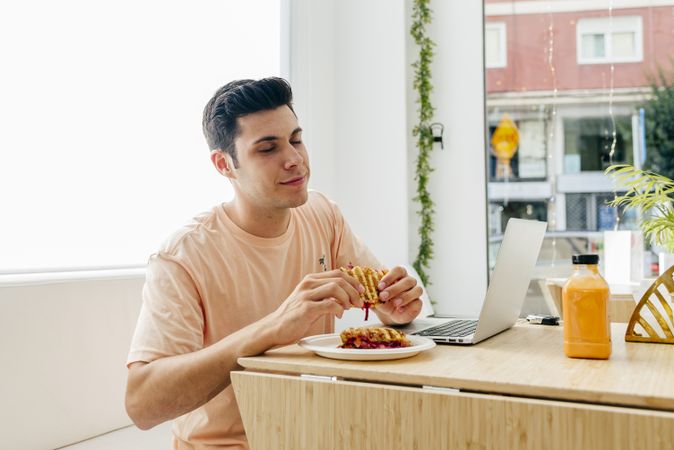 Cheerful guy enjoying dessert in cafe