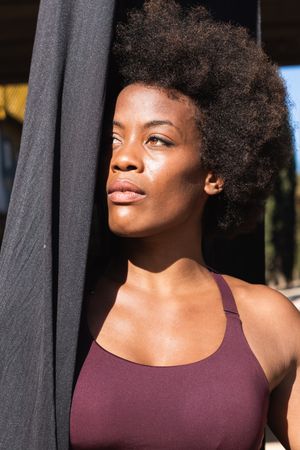 Fit Black woman with hammock for yoga in city