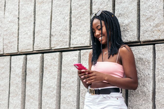 Portrait of a Black young woman enjoying in the city using smartphone