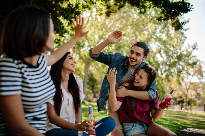 Young man giving high five to female friends at park