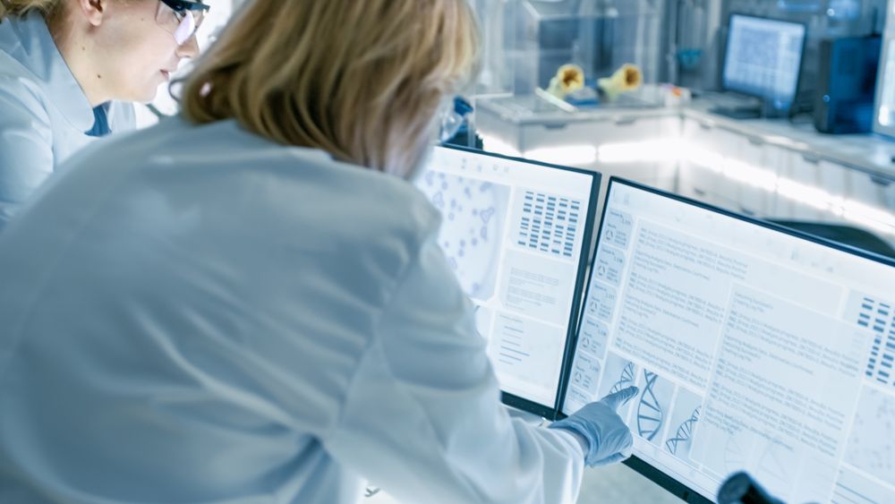 Mature Female Scientist Discusses Scientific Data with Her Laboratory Assistant.