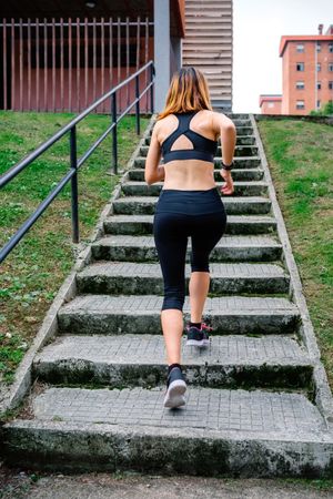 Female athlete climbing stairs outdoors