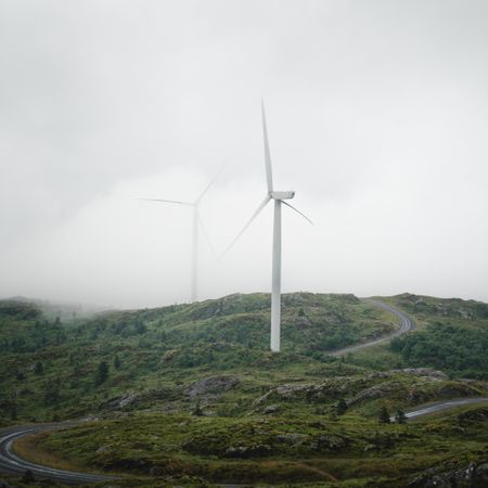 Wind turbine on green hill in Norway