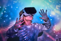 Delighted kid interacting with VR glasses in neon lights