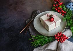 Christmas holiday concept of gift on plate garnished with holly