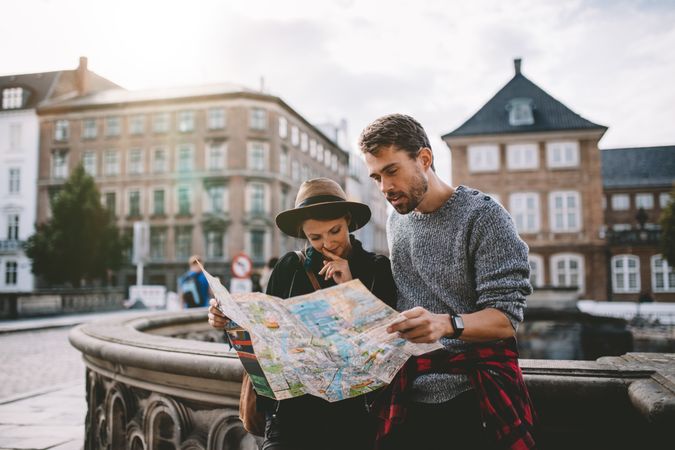 Young couple looking at a navigation map of old European city