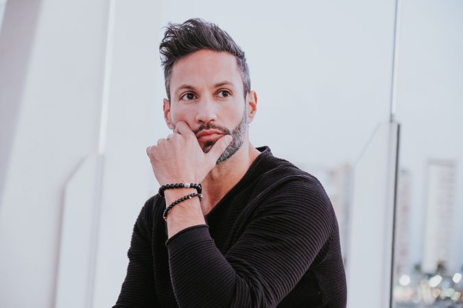 Adult stylish smiling man near grey wall on street