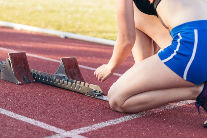 A female athlete getting ready to run on an athletics track.
