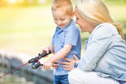 Young White Mother and Son Having Fun Fishing At The Lake